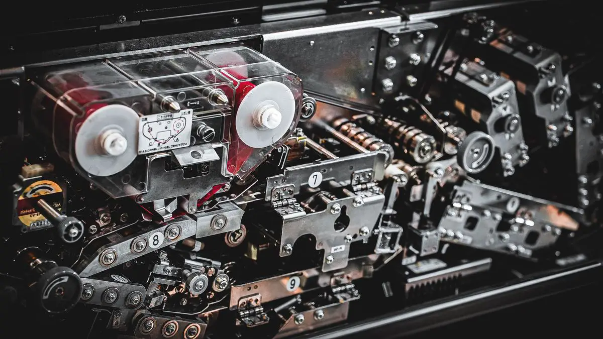 A person using compressed air to clean the internals of a gaming laptop, ensuring optimal performance and longevity.